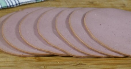 Canvas Print - Slider shot of sliced bologna on a wooden cutting board