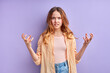 frustrated irritated young female spreading hands with shock and misunderstanding, what do you want gesture. Indoor studio shot isolated on purple background
