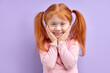 © alfa27 - Cute kid girl looking at camera cheerfully smiling, sweet child holding hands on cheeks, beautiful and funny kid with natural red hair in pony tails