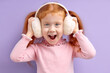 © alfa27 - Little Girl Have Fun While Listening To Music in Headphones , Attractive Redhead Child Stand With Opened Mouth Looking At Camera Cheerfully