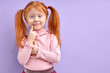 © alfa27 - Child girl with natural red hair stand thinking isolated on purple background touching chin looking at camera smiling curious copy space for text or product.
