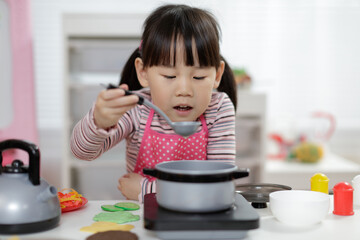 Wall Mural - young  girl pretend play food preparing at home