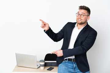 Russian man in a office isolated on white background surprised and pointing side