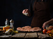 © Anton - In the frame, the chef prepares chicken fillet. In the photo, the process of preparing meat for frying. Salt meat cook. Also in the photo are other ingredients - tomatoes, garlic, cheese, sauce.