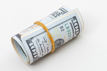 Canvas Print - US dollar rolled up with a rubber band isolated on white. the most popular money.