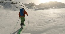 Relaxing sun rise ski tour in the austrian alps. Ski mountaineering in pure nature. Professional mountain guide enjoying the lonelyness in the snowy mountains.  Video shooting in Tirol. 4K follow cam.