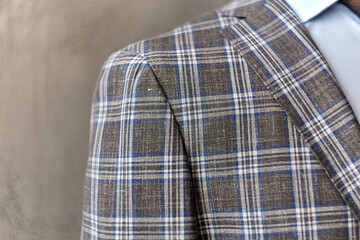 Men's casual checkered tweed coat and blue shirt shoulder closeup