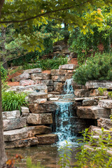 Wall Mural - Small stone waterfall during a summer day