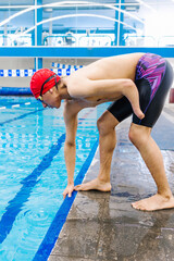 Young latin disabled sportsman jumping in the pool During A swimming training with hand hypoplasia in disability concept in Latin America