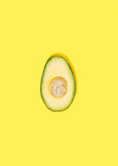 Wall Mural - green fresh avocado with shell in the middle on a yellow background.flat lay minimal creative idea