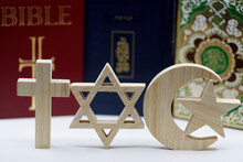 The Three Monotheistic Religions. Christianity, Islam And Judaism. Thorah, Quran And Bible With Croos, Star Of David And Muslim Crescent.  Interreligious Or Interfaith Symbols. France.