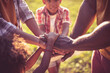 © liderina - African American family spending time in nature. Hand on hand.