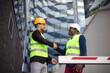 © liderina - Engineer discussing the structure of the building with architects colleague at construction site.
