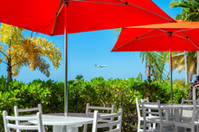 Beach Cafe In Caribbean Island In Montego Bay, Jamaica. Red Umbrellas And White Table In Beach Caribbean Restaurant. 