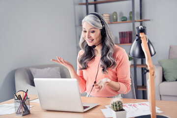 Portrait of elderly retired pensioner cheery woman marketer working remotely consulting client at home house flat indoor