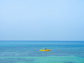 Wall Mural - Asian tourist on yellow Kayak boat in tropical island blue sea bright sun in summer. Koh Kood - Thailand