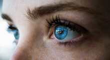 Primer Plano De Los Preciosos Ojos Azules De Una Chica Peliroja Con Pecas Reflejando Ventanal En Un Dia De Primavera