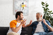 © LIGHTFIELD STUDIOS - Mature father and son talking in living room