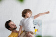 © LIGHTFIELD STUDIOS - Man holding smiling son gesturing at home