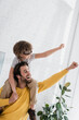 © LIGHTFIELD STUDIOS - Cheerful man playing with son in aviator goggles at home