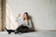 © Eugenio Marongiu - Young woman sitting floor indoor using computer celebrating success or shopping online during break