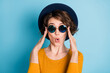 Photo portrait of amazed shocked woman in sunglass wearing shirt headwear isolated on bright blue color background