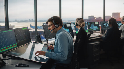 Wall Mural - Diverse Air Traffic Control Team Working in a Modern Airport Tower. Office Room is Full of Desktop Computer Displays with Navigation Screens, Airplane Departure and Arrival Data for Controllers.