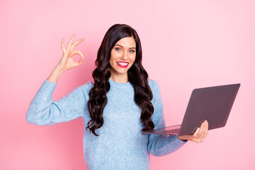 Poster - Photo of cute promoter girl hold netbook show okey wear blue pullover isolated pink color background