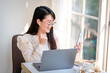 © Thinapob - Happy of asian freelance people Businesswoman writing message on smartphone and hold a coffee cup mug casual working with laptop computer at the cafe,Business Lifestyle