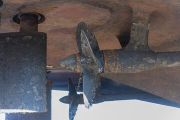 Wall Mural - Fixed blade propeller and rudder with shells. Cargo vessel ashore on ship repairing yard.