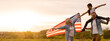 © Angelov - family holding up an American flag in a field.