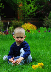 Wall Mural - little boy sits on the grass. Selective focus