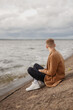 © Dmitri Krasovski - Young guy sits on the seashore.