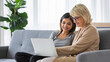 © Bangkok Click Studio - Young woman teaching mother to use laptop
