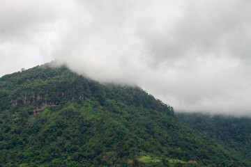  A beautiful mountain landscape with forest-covered peaks and cloudy skies.