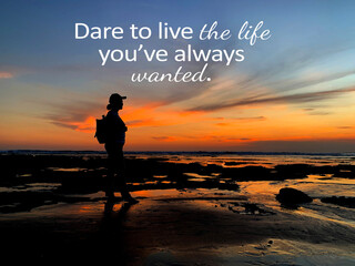 Inspirational quote - Dare to live the life you've always wanted. With silhouette of a adventurous young woman standing alone on the beach with a smile at sunset. Self motivation concept.