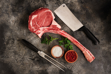 Raw tomahawk steak on wooden board