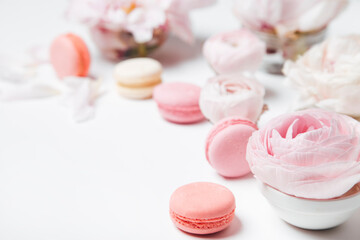 close-up view of pink and white macaroons, beautiful tender roses on a light background with copy space, selective focus 