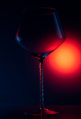 Wine glass on red light background, reflection