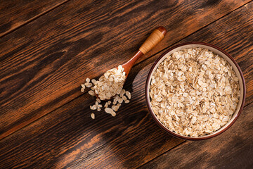 Wall Mural - Bowl with oatmeal flakes on a wooden background