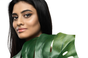 Wall Mural - Beautiful Indian woman with a smooth skin holding green tropical leaf