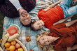 © gstockstudio - Top view of young beautiful family with little boy smiling while having picnic outdoors
