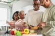 © Alessandro Biascioli - Happy African family having fun in modern kitchen preparing food recipe with fresh vegetables - Food and parents unity concept