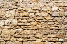 Yellow Stone Wall. Texture Of A Stone Wall Of An Old House.