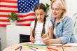 © Angelov - happy mother and daughter with american flag at home