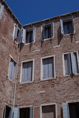 facades with blue wooden shutters of the narrow streets of the old city of Venice