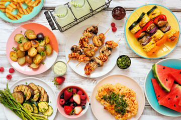 Wall Mural - Vegan summer bbq or picnic table scene. Overhead view on a white wood background. Fruit, grilled vegetables, skewers, cauliflower steak and lemonade. Meat substitute concept.