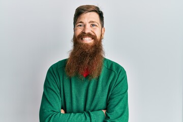 Redhead man with long beard wearing casual clothes happy face smiling with crossed arms looking at the camera. positive person.