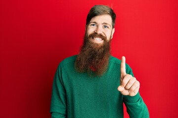 Sticker - Redhead man with long beard wearing casual clothes smiling with an idea or question pointing finger up with happy face, number one