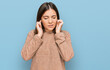 © Krakenimages.com - Young beautiful woman wearing casual clothes covering ears with fingers with annoyed expression for the noise of loud music. deaf concept.